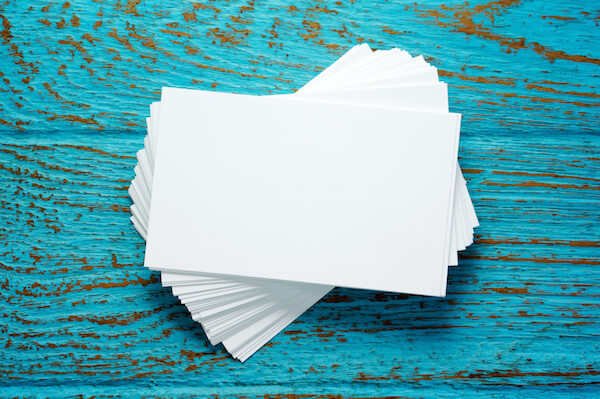 Stack of blank business cards on blue wood desk